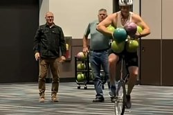 Man rides a unicycle with 7 bowling balls to break world record